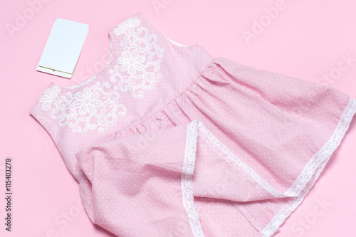 Clothes for baby girl on a pink background. Copy space for text