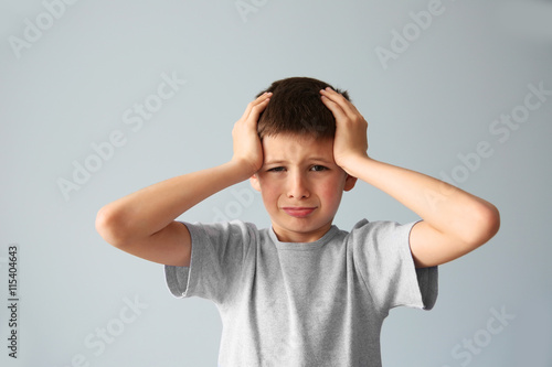 Portrait of upset boy with hands on a head
