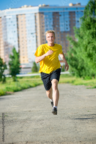 Running man jogging in city street park at beautiful summer day. Sport fitness model caucasian ethnicity training outdoor. © mr.markin