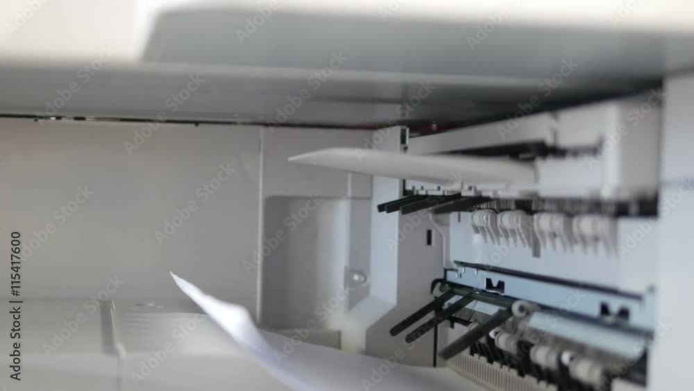 Office printer at work. Sheets of paper in a copier. Dolly shot