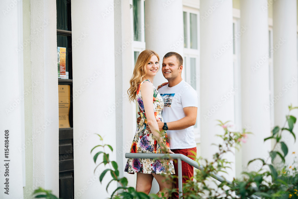 Attractive young couple lovely hugging in the city and looking at the camera. Photo with copy space at the left Attractive young couple lovely hugging in the city and looking at the camera. Photo with copy space at the left