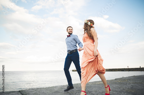 Wedding couple  bride  groom walking and posing on pier