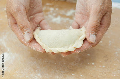 hands of confectioner hold preparation of roll