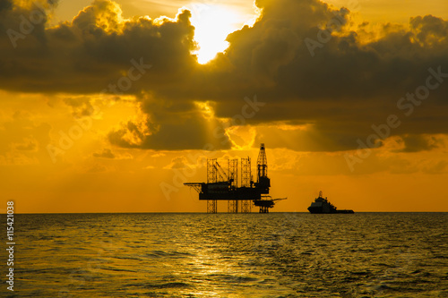 Silhouette,Offshore Jack Up Rig in The Middle of The Sea at Sunset Time photo