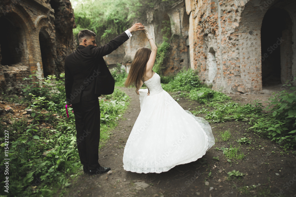 Happy newlyweds near the ancient castle on the walk Happy newlyweds near the ancient castle on the walk