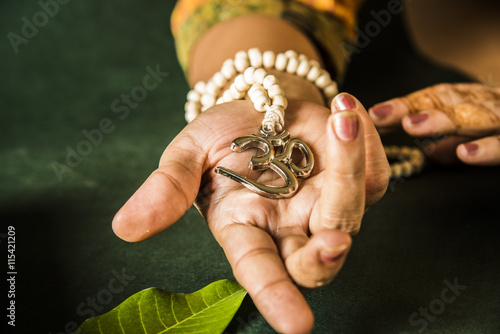 hand holding Aum locket with beads