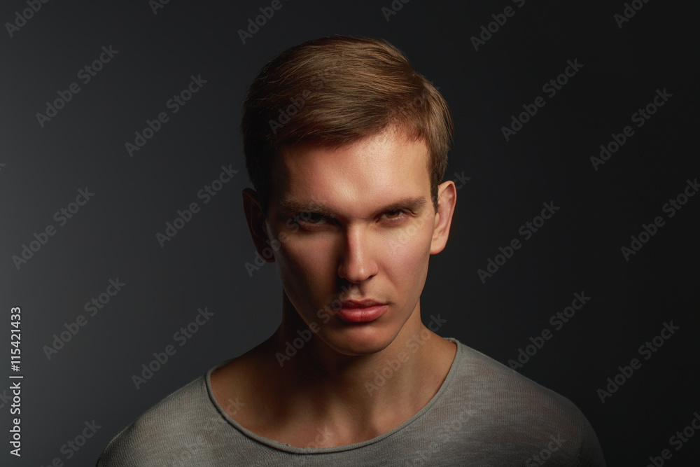 Dark fashion portrait of young angry man with contrast shadows Dark fashion portrait of young angry man with contrast shadows