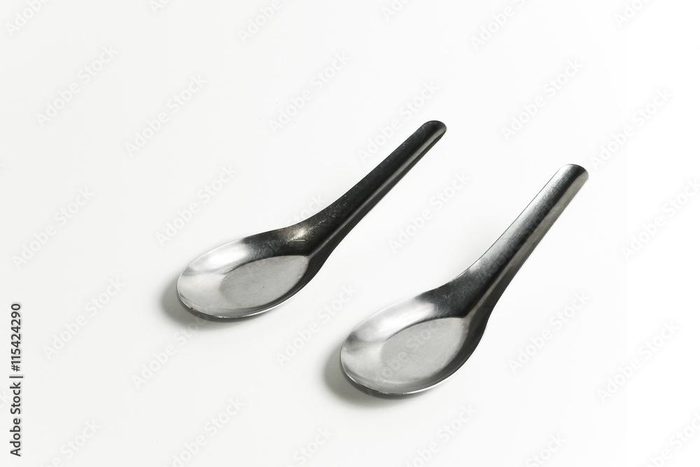 used two asian silver table spoons on white background used two asian silver table spoons on white background
