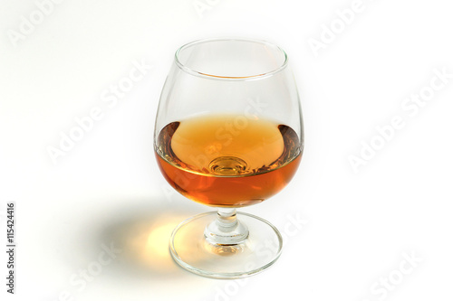 amber whiskey in snifter glass on white background