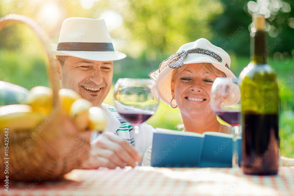 Beautiful mature couple having picnic in countryside Beautiful mature couple having picnic in countryside