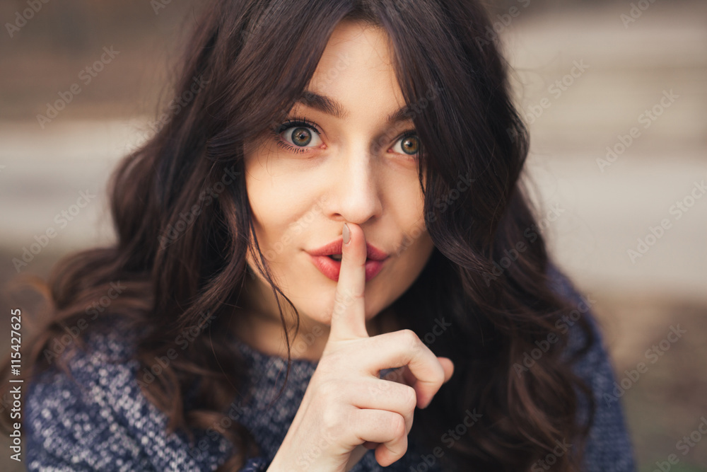 Naklejka premium Portrait of beautiful woman with finger on lips.