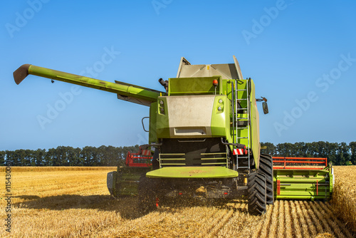 Green combine and blue sky.