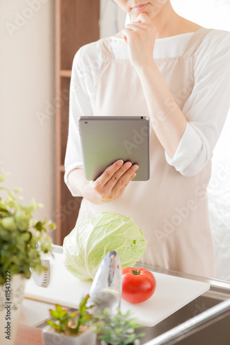 Wallpaper Mural エプロンを着た女性、タブレットでレシピを調べる Torontodigital.ca