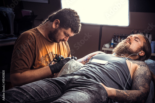 Professional tattooer posing in tattoo parlour