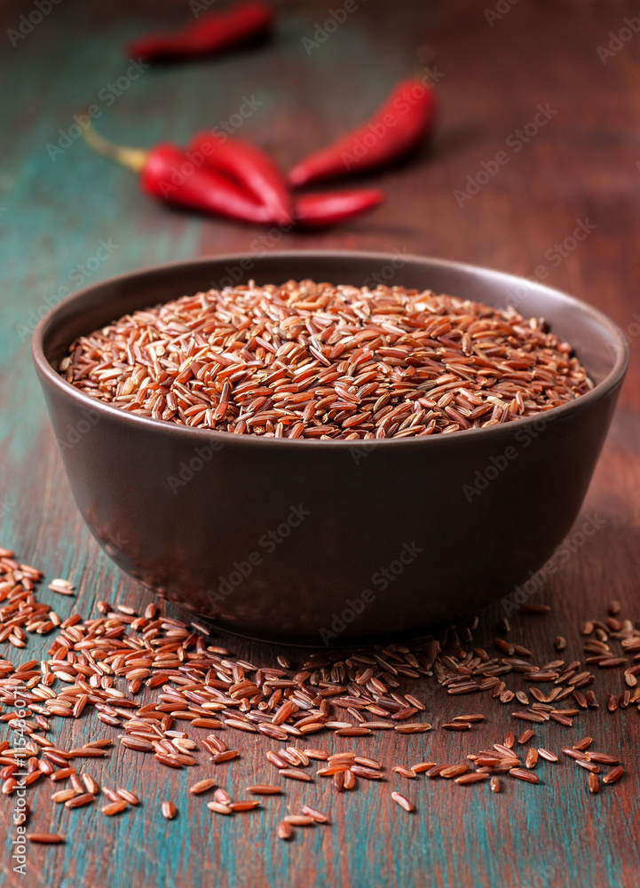 Bowl of red rice, chili peppers
