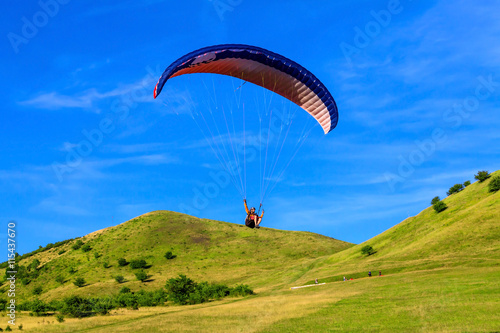Paraglider over the green valley