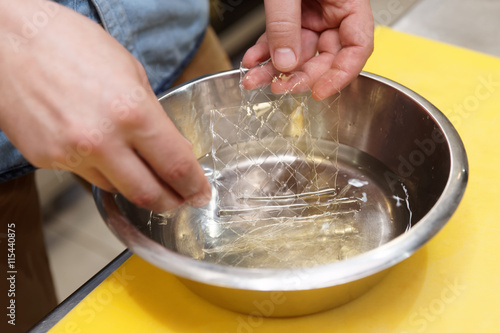 Chef is soaking gelatin sheets in water photo