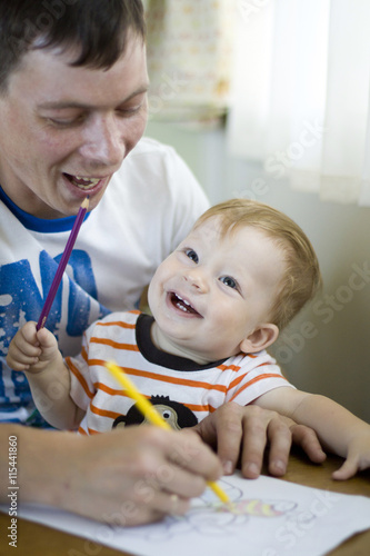 Dad draws with little smiling son