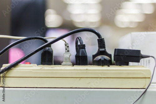 Multiple electricity plugs on adapter risk overloading and dangerous.