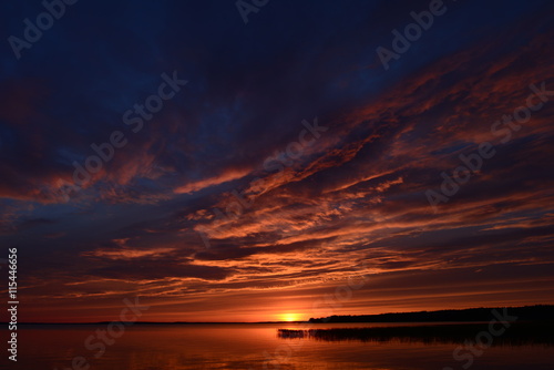 The sky over the lake in the light of the sunset of the summer sun