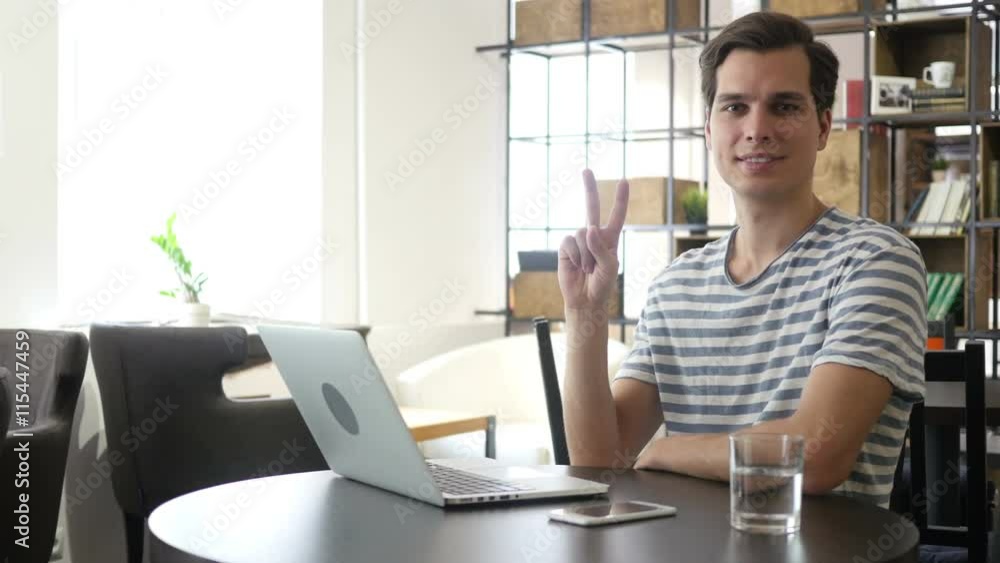 Portrait of a successful man showing victory sign or two fingers Portrait of a successful man showing victory sign or two fingers