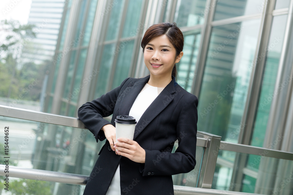 Business woman holding a coffee outside office Business woman holding a coffee outside office