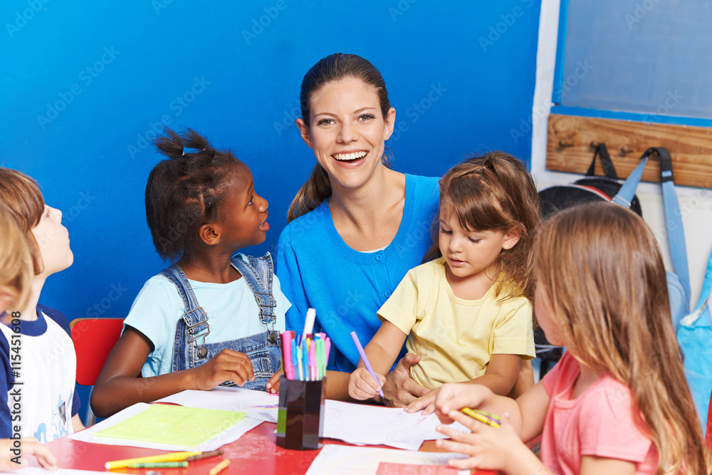 Erzieherin sitzt mit Kindern im Kindergarten Stock Photo | Adobe Stock