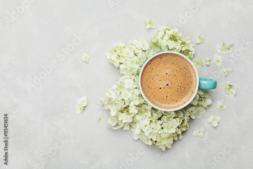 Morning Cup of coffee and a beautiful hydrangea flowers on light background, top view. Cozy Breakfast. Flat lay style.