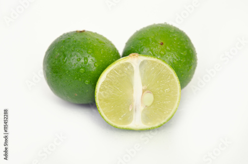 Lemon or lime fruit with half cross section isolated on white
