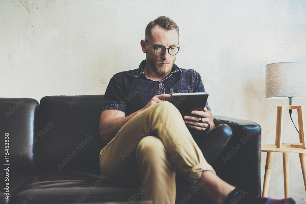 Stylish Businessman working tablet PC modern Interior Design Loft Office.Man relax Vintage sofa use contemporary device Hand.Blurred Background.Creative Business Startup Idea.Horizontal,Film effect.