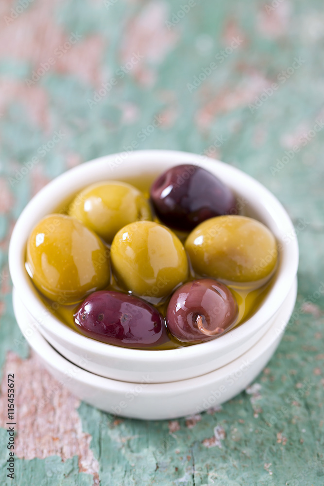 olives in a bowl on wooden surface olives in a bowl on wooden surface