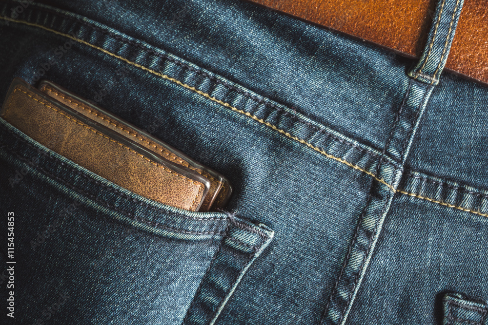 Leather wallet in back pocket of blue jeans vintage color