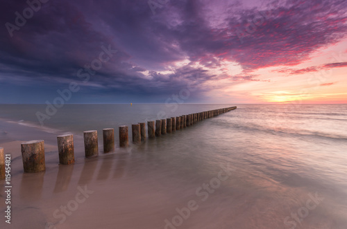 Wooden breakwater - Baltic seascape at sunset, Poland © tomeyk