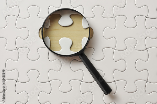 Foto Magnifying Glass On Missing Puzzle