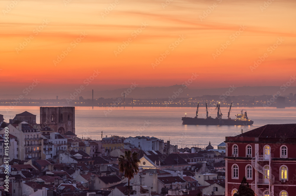 Lisbon cathedral, old city and Tag estuary with anchoring ship in the dawn, Portugal