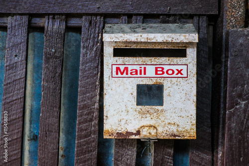 Mailbox hanging on wooden fence