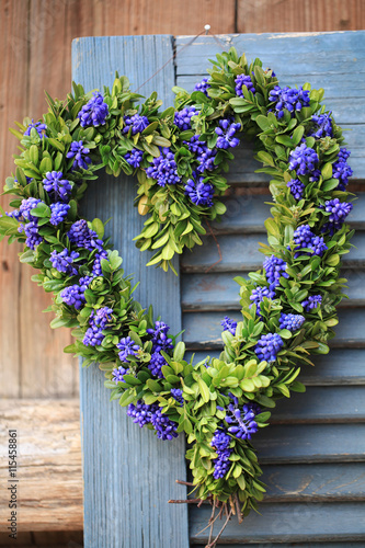 Fototapeta Naklejka Na Ścianę i Meble -  Door wreath in heart shape with boxwood and grape hyacinth flowers