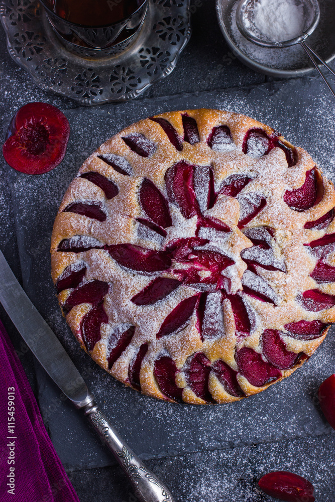 rustic plum cake on dark background rustic plum cake on dark background