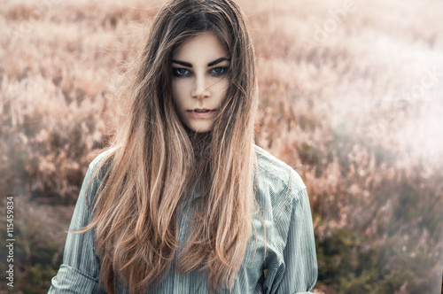 Beautiful and young girl in a man's shirt standing in the field. Fog.
shirt for the girl. Nature. Wind inflates hair.