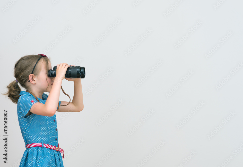 Little girl looking through binoculars. Space for your text. Little girl looking through binoculars. Space for your text.