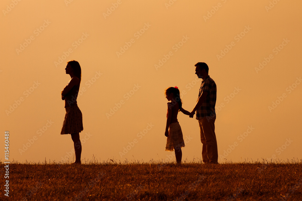 Silhouette of a angry wife turning back while her husband and daughter are looking at her. 