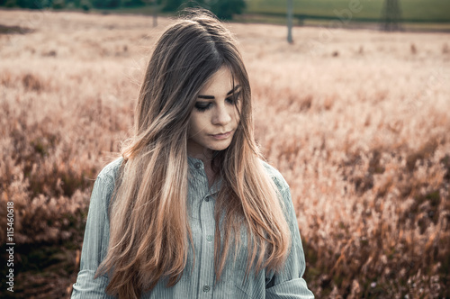 Beautiful and young girl in a man's shirt standing in the field.
shirt for the girl. Nature. Wind inflates hair.