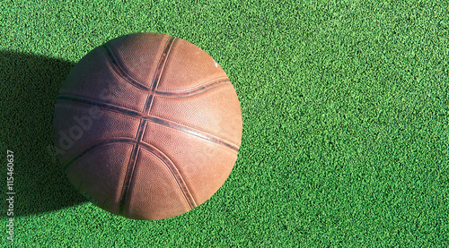 Basketball ball on green field floor