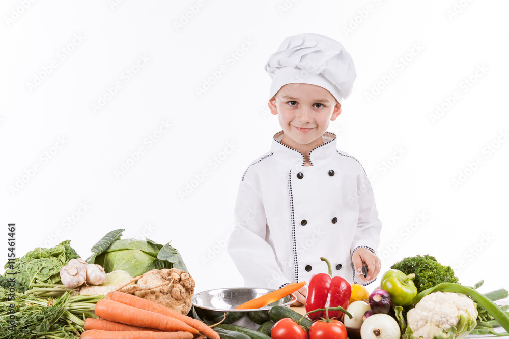 One little boy as chef cook making salad, cooking with vegetable One little boy as chef cook making salad, cooking with vegetable