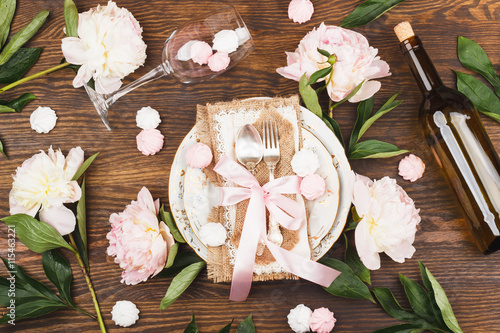 Tableware with light pink peonies and meringues photo