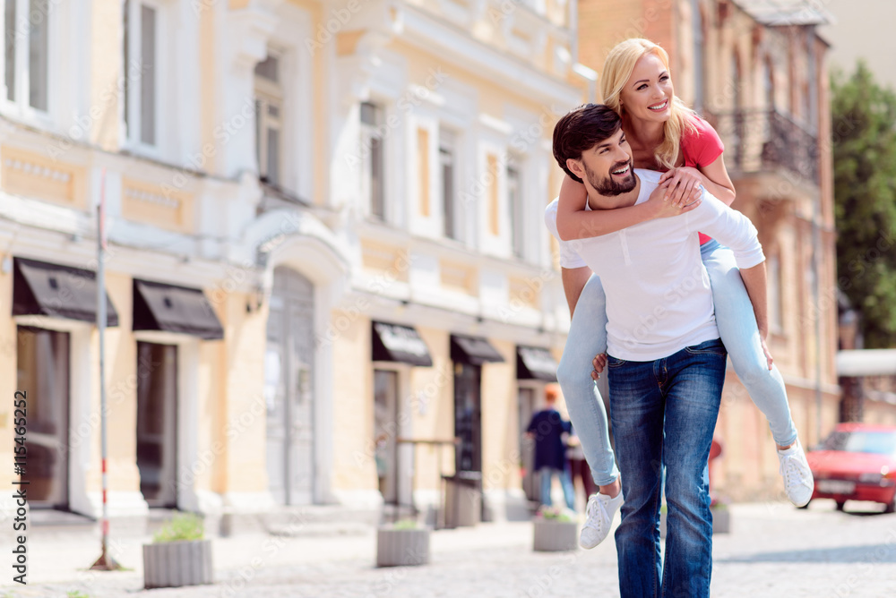 Joyful lovers having fun on street