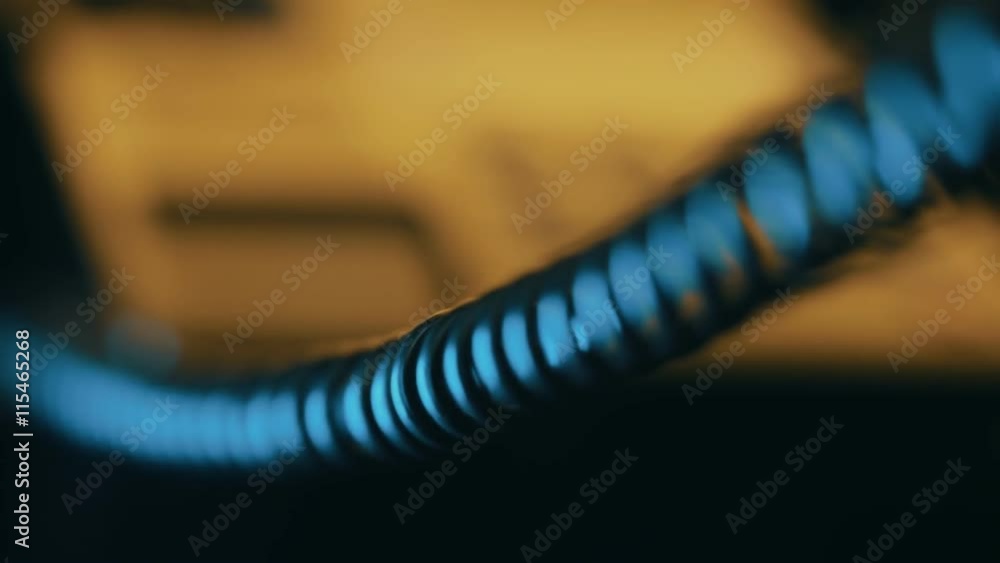 In the dim light, follow focus from black buttons to a telephone coiled cord In the dim light, follow focus from black buttons to a telephone coiled cord