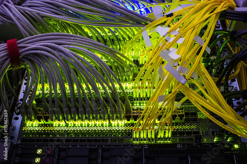 cables connected to an optic ports and UTP Network cables connected to ethernet ports. photo