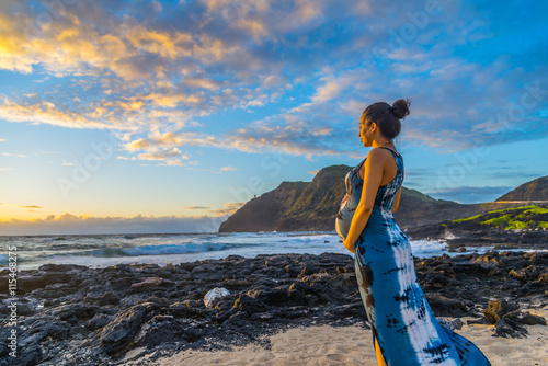 Pregnant young woman expecting baby with father on beach in tropical paradise.