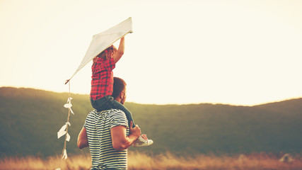 happy family father and child on meadow with a kite in summer